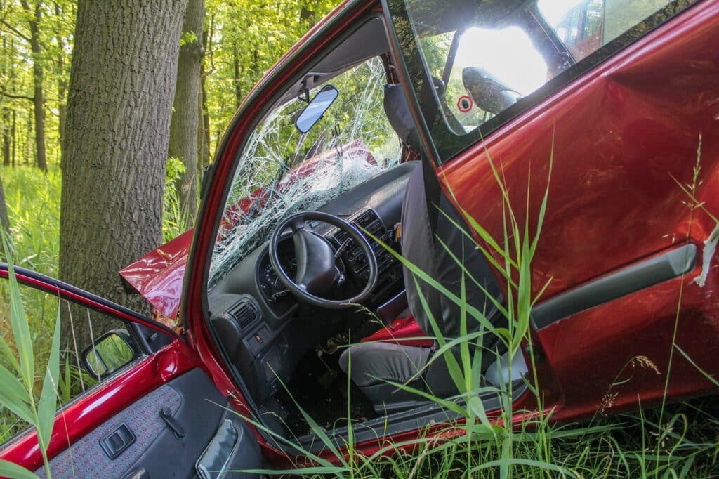 Autounfall: Rotes Auto gegen Baum geprallt.