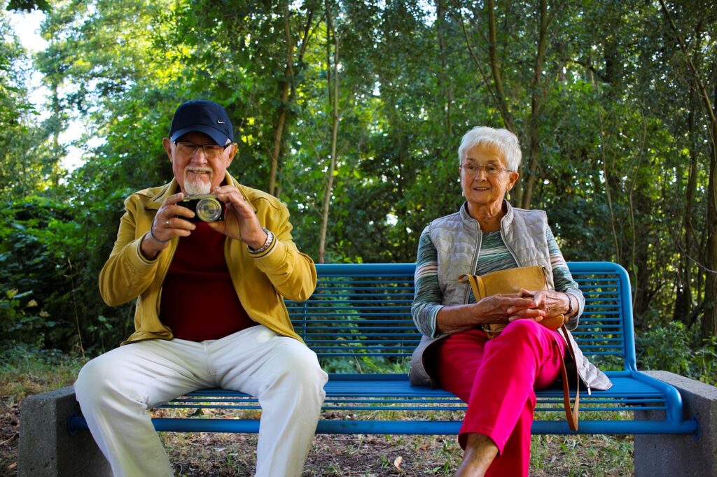 Älteres Paar sitzt auf einer Bank im Park.