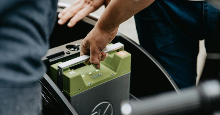 E-Bike-Wechselakku wird aus der Halterung eines Elektrofahrzeugs genommen