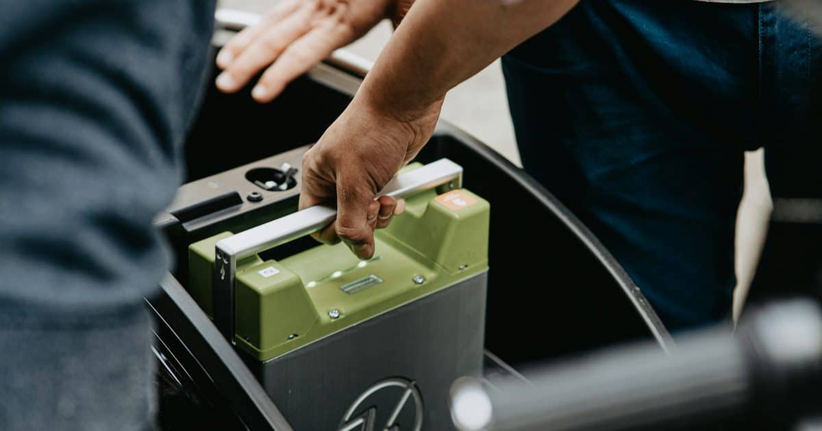 E-Bike-Wechselakku wird aus der Halterung eines Elektrofahrzeugs genommen