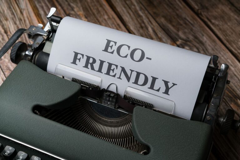 Alte Schreibmaschine mit eingespanntem Blatt, auf dem in großen Buchstaben „Eco-friendly“ steht