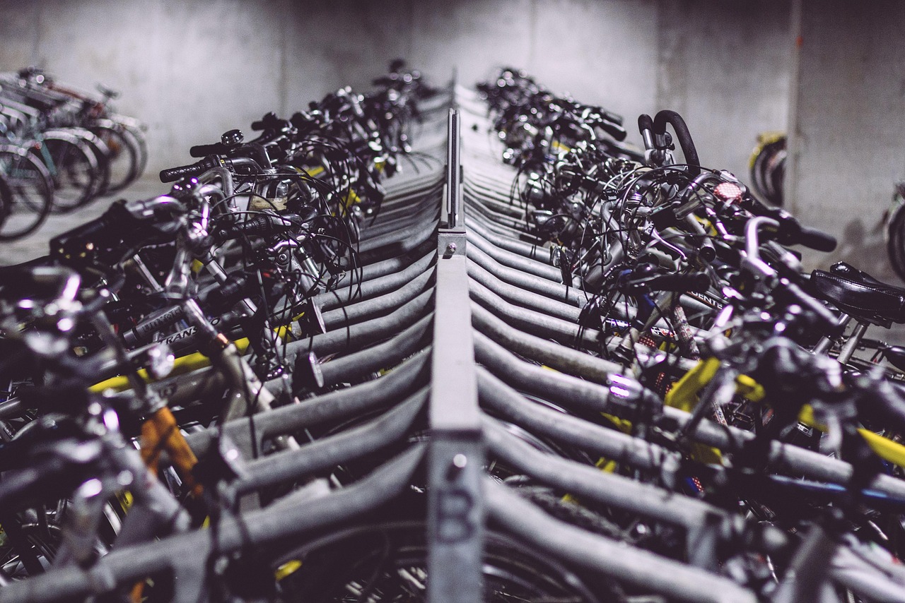 Lange Reihe abgestellter Fahrräder in einem Fahrradständer in einem Abstellraum mit Betonwänden